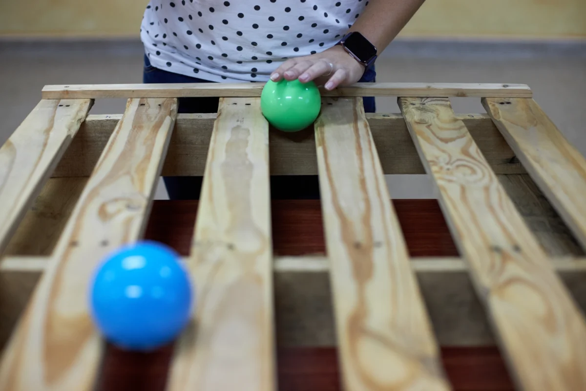 Professor aprenent tècniques de malabarisme amb una pilota purpura durant el taller de Flux de troposfera.xyz, dirigit per Dídac Gilabert, per ensenyar estudiants.